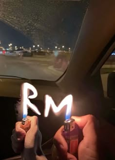 two people holding lighters in their hands with the word r m written on them