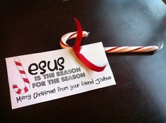 a candy cane is sitting on top of a card that says egus is the reason for time season