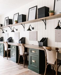 a row of desks with chairs and pictures on the wall