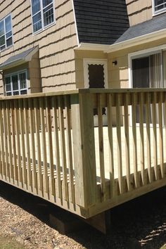 a wooden deck in front of a house with windows and sidings on the side