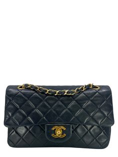 We  the ity of this Chanel Quilted Lambskin Small Classic Double Flap Bag crafted in supple dark navy blue diamond quilted lambskin leather and gold-tone hardware. This iconic bag features a chain link and leather shoulder strap that can be  long or doubled, an exterior rear pocket and a double front flap with signature  CC turn lock closure. Condition: Very Good. The exterior front and rear of the bag is overall clean with minor wear and scuffing. Faint creasing and indentations are present. Gentle rubbing has developed on the bottom edge corners and at the corners of the flap. The gold-tone hardware shines bright but has very minor tarnishing on the shoulder straps chain links and on the front turn-lock closure. The leather under the inside flap has scratches. The interior lining is clea Chanel Flap Bag, Versace Bags, Iconic Bags, Dark Navy Blue, Diamond Quilt, Girl Backpacks, Exclusive Bag, Blue Diamond, Flap Bag