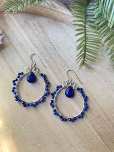 Beautiful Blue!! These wire wrapped hoop earrings feature genuine lapis lazuli gemstone beads. Sparkly lapis gems attached to the hoop with lapis teardrop bead in center. These are gorgeous and stylish!  One of a kind beauties! These hoop earrings have ear wires in sterling silver and come with clear backings. Thank you so much for checking out my shop! Every jewelry purchase comes in a nice box with a free gift.  Please feel free to send me a message if you have any questions. I appreciate all Wrapped Hoop Earrings, Gemstone Hoop Earrings, Lapis Lazuli Gemstone, Earrings Wire, Earring Ideas, Teardrop Beads, Beaded Hoop Earrings, Beaded Hoops, Gift For Friend