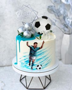 a birthday cake with a soccer player on it and decorations around the top tiers