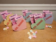 some candy hearts are sitting on a table with the word be mine written on them