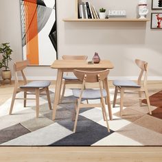 a dining room table and chairs in front of a painting