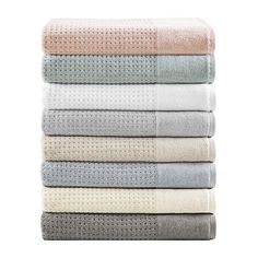 four towels stacked on top of each other in various colors and patterns, with one folded