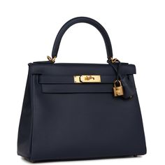 This Kelly, in the Retourne style, is in Bleu Nuit evercolor leather with gold hardware and has tonal stitching, front flap, two straps with center toggle closure, clochette with lock and two keys, single rolled handle and removable shoulder strap. The interior is lined in Bleu Nuit chevre and has one zip pocket with Hermes engraved pull and two open pockets on the opposite side.Collection: ZOrigin: FranceCondition: Pristine; new or never (plastic on hardware)Accompanied by: Hermes box, Hermes dustbag, clochette, lock, two keys, shoulder strap, clochette dustbag, shoulder strap dustbag, felt, rainhat and carebookMeasurements: 11.25" width x 8.25" height x 4.75" depth; 3.5" handle drop Luxury Navy Bag With Main Compartment, Luxury Blue Box Bag With Gold-tone Hardware, Luxury Designer Navy Bags, Luxury Navy Bags With Zipper Closure, Classic Luxury Navy Bags, Luxury Blue Shoulder Bag With Cc Turnlock Closure, Hermes Kelly Retourne, Kelly Retourne, Hermes Box