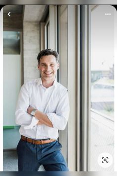 a man standing in front of a window with his arms crossed