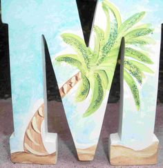 the letter m is painted with an image of a palm tree