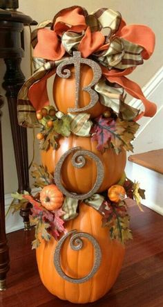 a decorative pumpkin sitting on top of a wooden floor next to a stair case and table