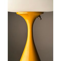 a yellow table lamp with a white shade