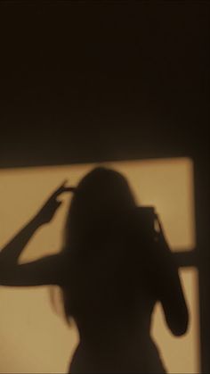 the shadow of a woman's head is shown in front of a window