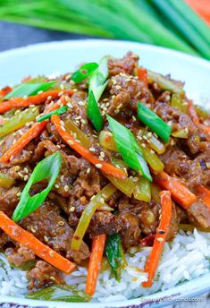 a close up of a plate of food with meat and vegetables on top of rice