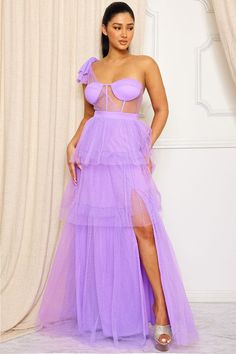 The Farrah Tulle Dress Lavender is perfect for an evening look. This maxi dress features a unique mesh one shoulder bustier top with a sheer mesh bust, a tie shoulder for comfort, and a multi-layer ruffles skirt that creates a billowy silhouette. The dress closes at the back with a zipper closure. Fits True To Size Model 5’8 Wearing A Small Tulle One Shoulder Dress For Prom, Lavender Maxi Dress For Summer Prom, Spring Night Out One Shoulder Floor-length Dress, Strapless Purple Maxi Dress For Party, Sheer Purple Party Dress, Purple Sheer Party Dress, Spring Strapless Tulle Maxi Dress, Purple Off-shoulder Maxi Dress For Party, Purple One-shoulder Maxi Dress For Party