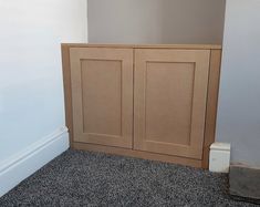 an empty room with a wooden cabinet in the corner and carpet on the floor next to it