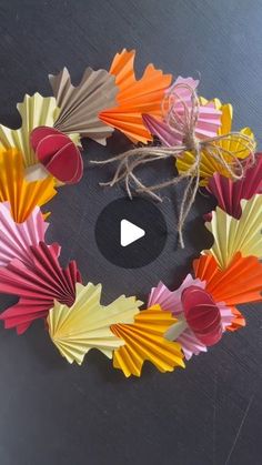 colorful paper fans arranged in a circle on a black surface with the words, how do you make?