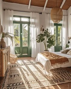 a bedroom with a bed, rugs and potted plants in front of the windows