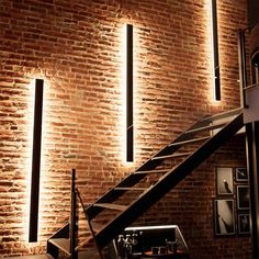 a brick wall with some lights on it and stairs leading up to the top floor