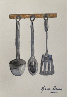 three metal utensils hanging from a wooden bar on a white wall with writing underneath