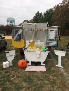 an outdoor bathtub with balloons and rubber ducks in it on the grass next to other decorations