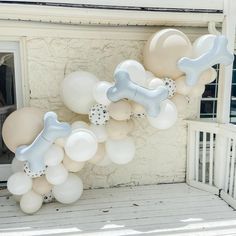 balloons are arranged in the shape of a dog bone and bones on a house porch