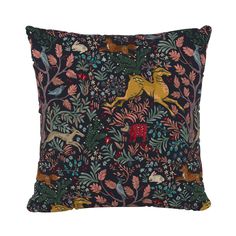 an embroidered pillow with animals and plants on it, in black fabric that has gold foiling