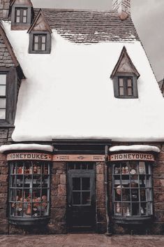 an old stone building with two windows and snow on the roof is shown in winter