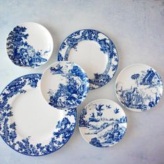 five blue and white plates with trees on them are arranged in a circle, one is empty