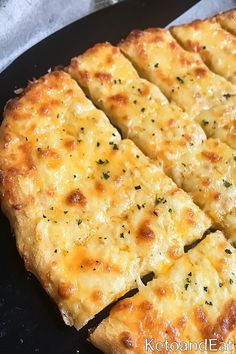 cheese pizza cut into eight pieces on a black plate