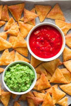 tortilla chips with salsa and guacamole in bowls on a tray