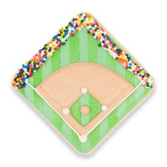 a decorated cookie shaped like a baseball field with sprinkles on the top