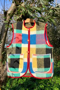 a multicolored vest hanging from a tree