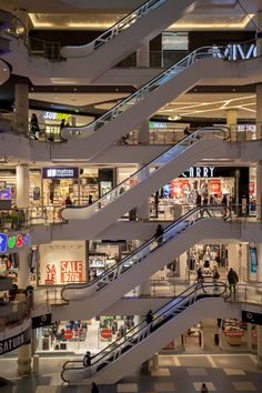 an escalator in a shopping mall with people walking around