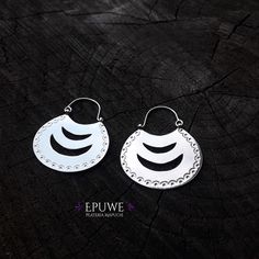 pair of silver earrings with black and white designs