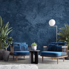 a living room with blue couches and potted plants