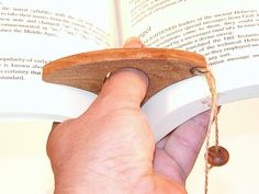 a person holding an open book in their left hand and touching it with the other hand