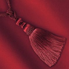 a tasseled necklace on a red background