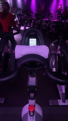 a close up of a bike handlebar in a room with purple lights behind it