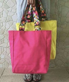 a person holding a pink and yellow bag