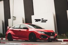 a red sports car parked in front of a building with custom stickers on it