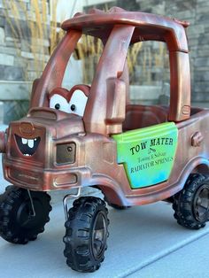 a toy truck with two large wheels and a tow matere sign on the front