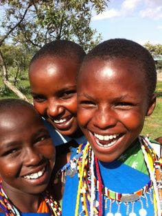 three young children are smiling for the camera