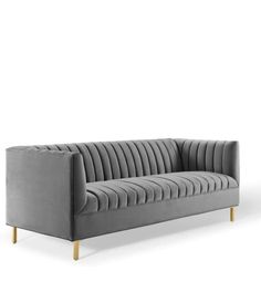 a grey velvet couch with gold legs on an isolated white background, viewed from the front