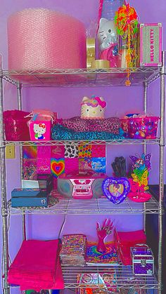 a shelf filled with lots of different items on top of a purple wall next to a lamp