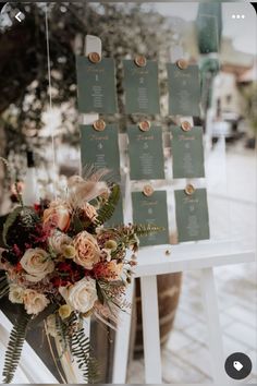 a bouquet of flowers sitting on top of a white chair next to a table with seating cards