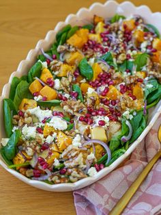 a salad with spinach, feta cheese and pomegranates in a bowl