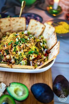 a bowl filled with food sitting on top of a table next to sliced avocado