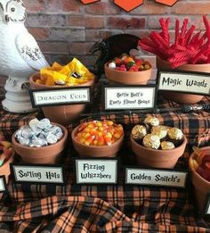 a table topped with lots of different types of candy and candies next to a brick wall