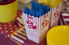 there is a yellow bowl with blue straws in it next to some red and white striped cups