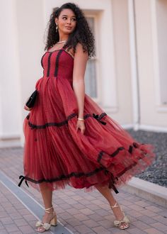 Grace, Elegance, & A Touch Of Glamour The quickest way to look cute this season. This stunning red dress is layered with delicate tulle, accented by classic black lace details and playful bows along the skirt. Its flattering A-line silhouette creates a graceful, flowing movement, perfect for festive gatherings or any holiday soireé. Pair with statement heels and vintage accessories to channel that sophisticated, old-money charm. Sweetheart neckline Black lace detailing Fixed straps Fitted waistline Back zipper True to size Model Details Content + Care 100% Nylon Hand Wash Only Hang Dry Try-On Video Audrey Dress Try-On Video XS & XL Holiday Soiree, Statement Heels, Audrey Dress, Dreamy Dress, Holiday Wardrobe, Vintage Accessories, Sweetheart Neckline, Lace Detail, Classic Black